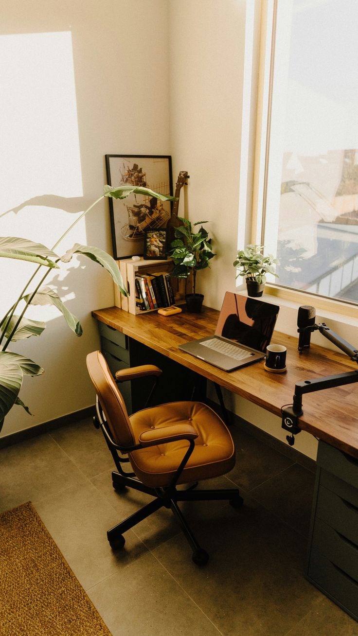 a desk with a laptop and a potted plant